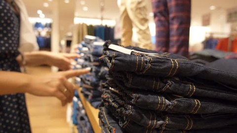 Woman Shopping for Jeans in Store. Closeup. HD, 1920x1080.  