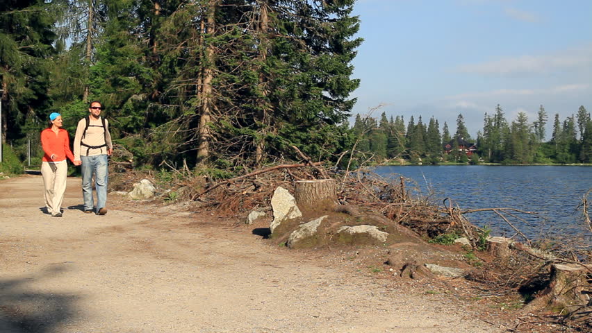 Couple on a trip by the beautiful lake in the woods 