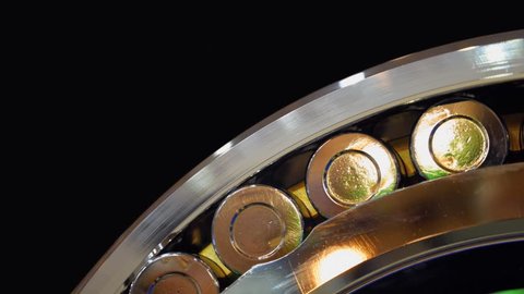 Chrome surface of the roller bearing shines brightly in different colors. Closeup. Shallow depth of field