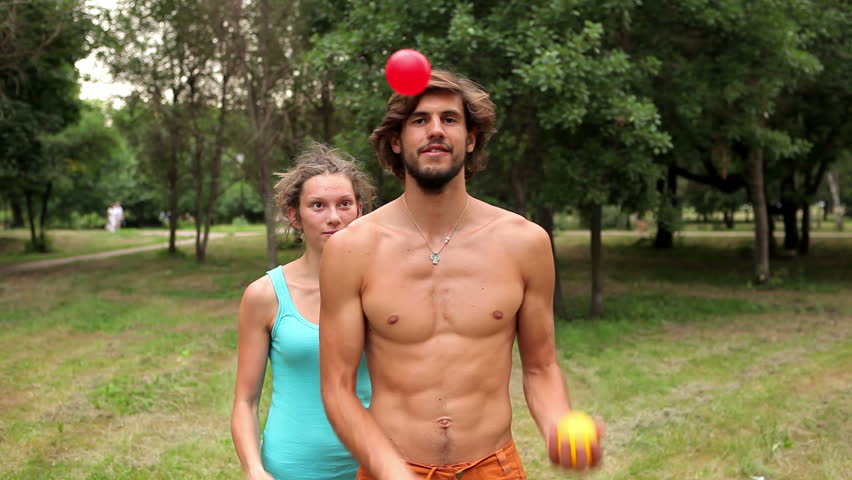 Girl grabs balls as guy is juggling Shutterstock HD Video #1304986.