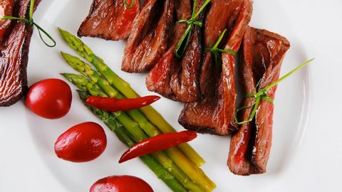 grilled red beef meat rolls with asparagus and hot spices on china plate 1920x1080 intro motion slow hidef hd