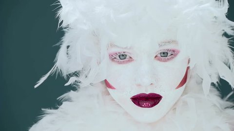 portrait of a woman mime or a clown and bodypainting white with red lips and red eyes
