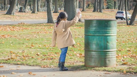 Child picking up litter, helping to clean environment  Stock video