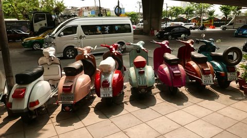 BANGKOK - MARCH 19, 2015: Old vintage motor scooters stand for sale on road side, against city traffic. Mahaisawan road at Thonburi district of Bangkok. Very old motorbike sale exposition