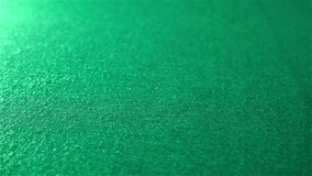Slow motion of rolling red dice on green background