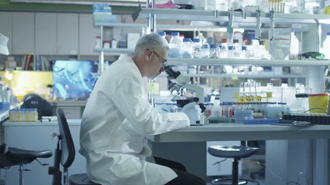 Male scientist is working on a microscope in a laboratory. Shot on RED Cinema Camera in 4K (UHD).
