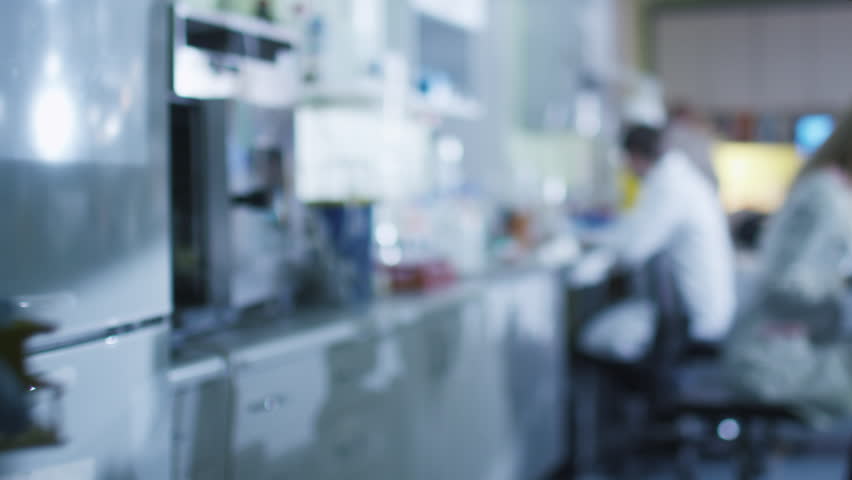 Team of caucasian scientists in white coats are working in a modern laboratory. Shot on RED Cinema Camera in 4K (UHD).