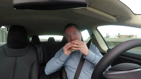 Severely distracted driver, eating lunch and texting while driving. Safety note: this clip was carefully created under controlled conditions.