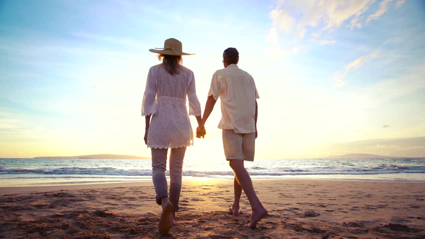Tropical Resort Vacation. Older Couple Holds Hands and Walks Down Beach into Sunset | Shutterstock HD Video #13077539