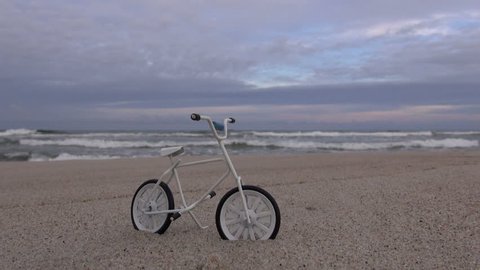 Little toy bicycle on the beach by the sea 