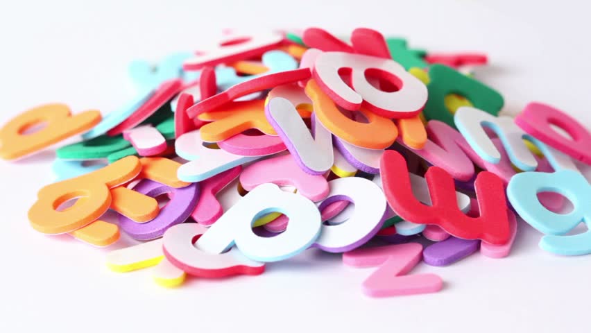 Letters piled in a heap, have different color one side, the other white, composition rotates