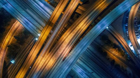 Static vertical top down aerial view of traffic on freeway interchange at night. 4K UHD timelapse background