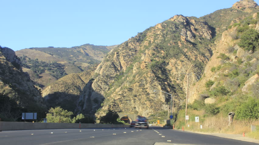 Cars zoom by on a mountainous stretch of the 101 Freeway on the Golden Coast
