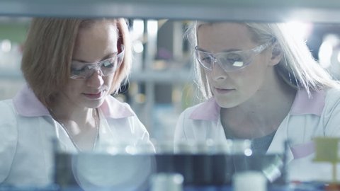 Two female scientists are working with  liquid samples in a tube in a laboratory. Shot on RED Cinema Camera in 4K (UHD).