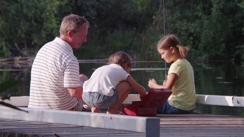 Father with son and daughter on fishing dock