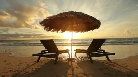Cinemagraph - Sunrise at tropical beach with chairs and hut. Looping Motion Photo. 