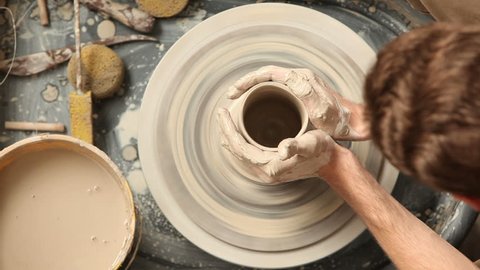 Cinemagraph - Overhead view of man making pot on pottery wheel. Looping Motion Photo. 