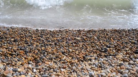 Close up of gentle waves against pebble beach