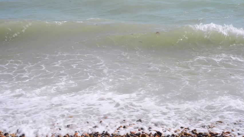 Close up of gentle waves against pebble beach
