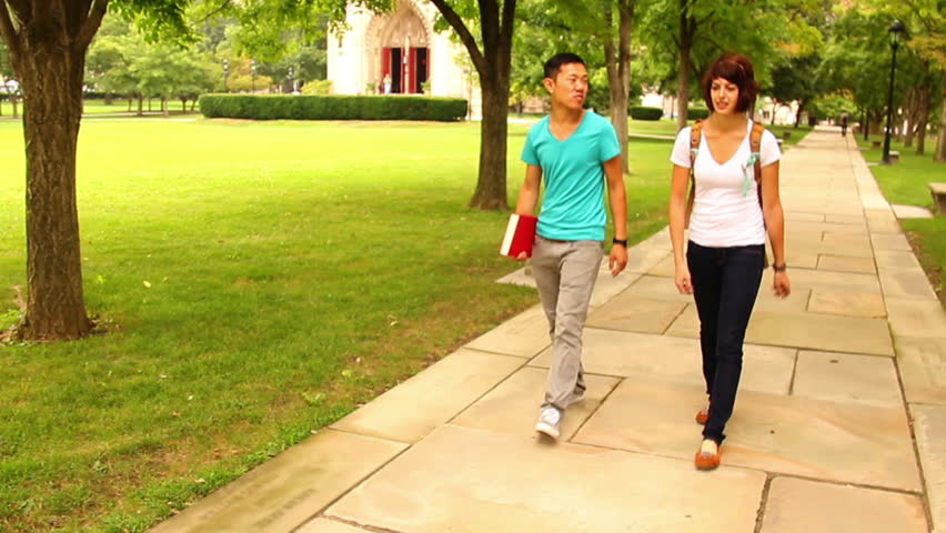 Students meet and walk on a college campus.