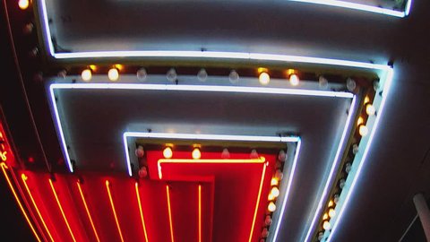 Low angle shot looking up while walking under bright casino lights on Fremont Street in Las Vegas Nevada. Generic neon tubes of light pass by overhead. 