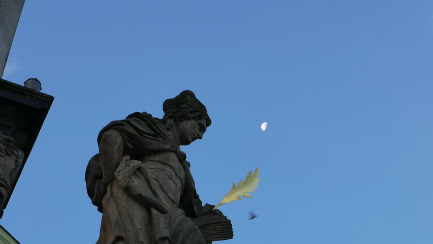 Sculpture of St.John the Evangelist at the fountain column on the main square (Namesti Svornosti), Cesky Krumlov (Bohemian Crumlaw), South Bohemian Region, Czech Republic. (UNESCO World Heritage Site)