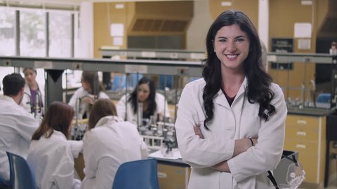 Portrait of a student in a science lab putting on safety goggles and smiling Stock Video
