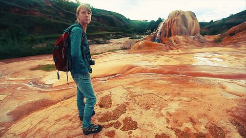 Lady with backpack watching on Analavory geysers. Madagascar.