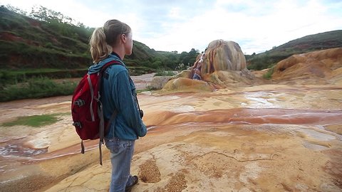 Lady with backpack watching on Analavory geysers. Republic of Madagascar.