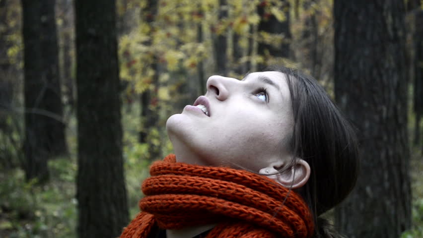 Youg woman in forest looking on the trees