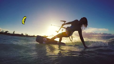 Extreme Kitesurfing at Sunset. Summer Ocean Sport in Slow Motion. Girl Kite Surfing in Bikini
