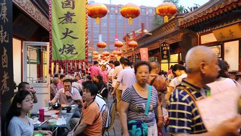 BEIJING - CIRCA JUNE , 2015: People on the Wangfujing snack street in Beijing. The famous Wangfujing snack street adjacent to the Wangfujing street, enjoys great popularity in the tourists and locals