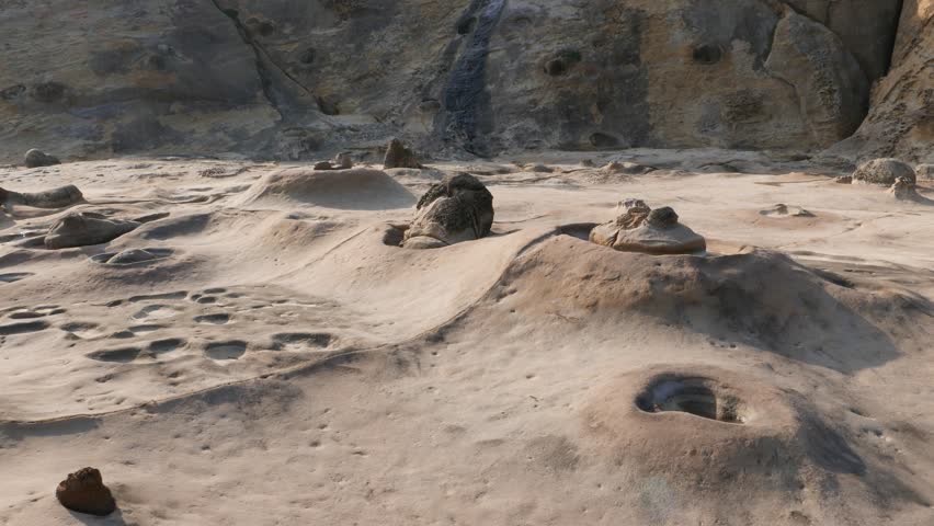 Sea candle formation at cape shore, odd Yehliu Geopark landscape. POV walk around. Rock hill at background, flat area ahead washed and weathered. Nature create different shapes and erosional figures
