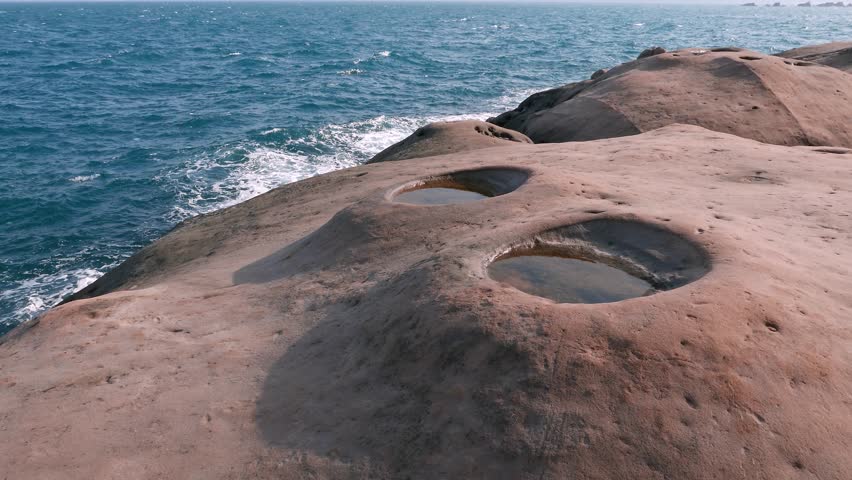 Tide pools, perfectly round hole in the rock, eroded or weathered. Typical part of fantastic Yehliu Geopark landscape. Nature-made round hole (s) in the smooth polished rock