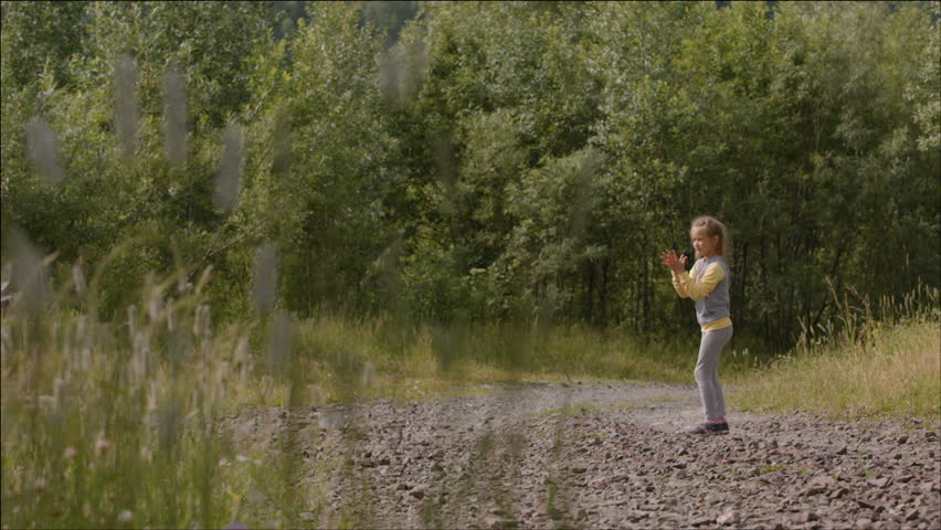 Little girl plaing with a dog on a chain