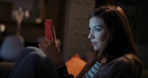 Beautiful brunette woman using digital tablet computer technology at home having late night video chat with friend blue glowing light on face