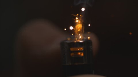 Lighter (black) sparking and lighting from the front - top cut off macro in slow motion shot at 1000 frames per second on a Phantom Flex 4k - alpha matte - black background