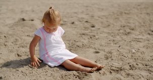 Young Beautiful Girl Playing in Sand at the Beach on Slow Motion Video