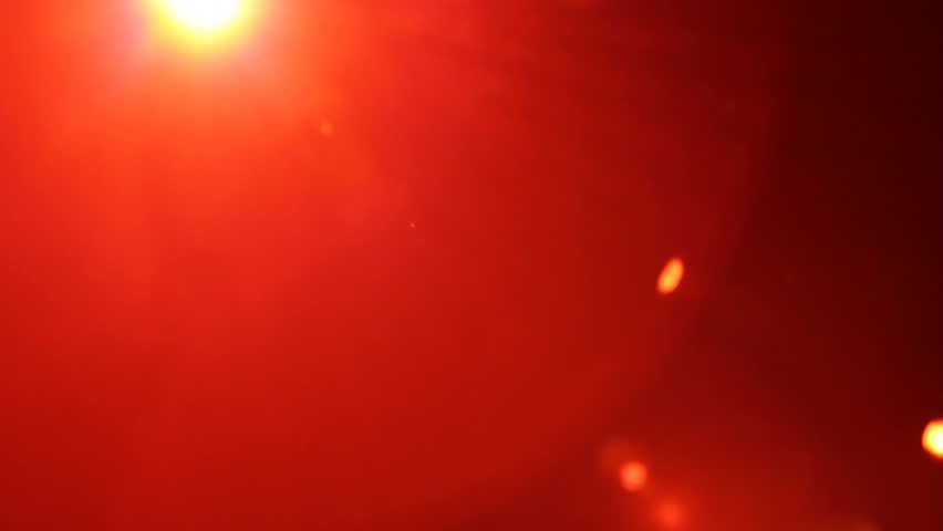 Professional stage lights on a dark stage. Red lights move around and flare the