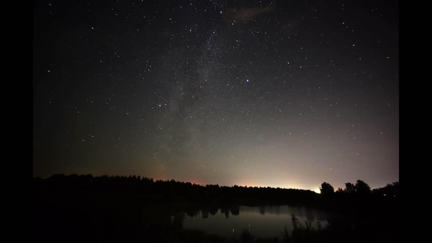 timelapse video of rotating stars in the night sky over the lake