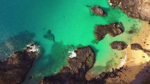 Aerial view of a couple diving / snorkeling thru the corals on a paradise beach, during a romantic adventure vacations trip.
