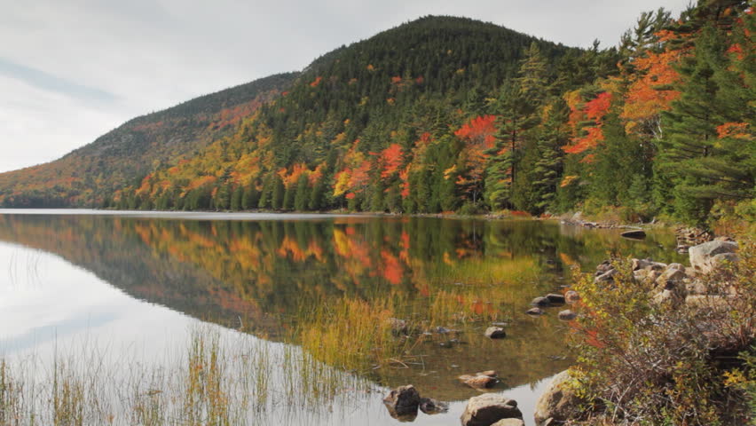 Bubble Pond in Acadia National Park, Maine, reflecting colorful Fall foliage and the slopes of Pemetic Mountain.