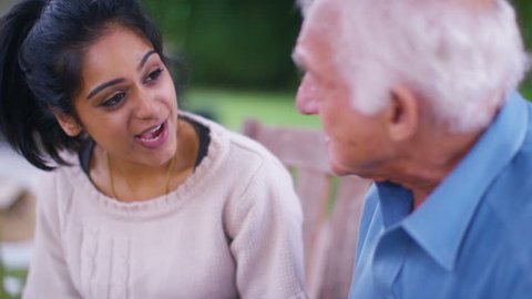 4K Caring young home support worker spending time with elderly gentleman in the garden. Shot on RED Epic