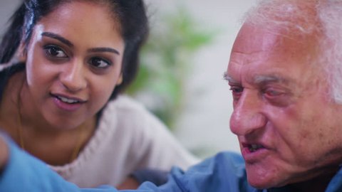 4K Caring young home support worker spending time with elderly gentleman in his home. Shot on RED Epic