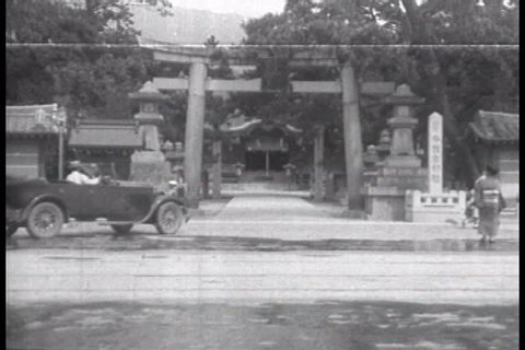 CIRCA 1920s - Japan, home to a General Motors Company facility, is shown with a Torii, a woman in a kimono, a man carrying with a carrying pole and general city scenes in 1927.