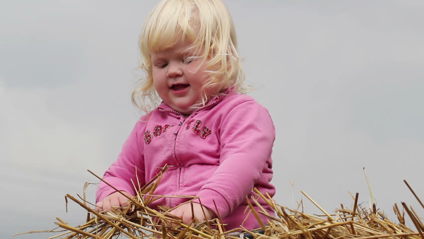 little girl indulges in a haystack