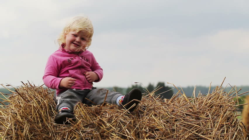 little girl indulges in a haystack
