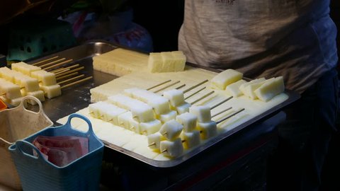TAIPEI, TAIWAN - FEBRUARY 15, 2015: Tray with chinese white sponge sugar cake, sticking on a stick, close up view of the process. White sugar cake sponge also called white cake sugar, pastry sugar