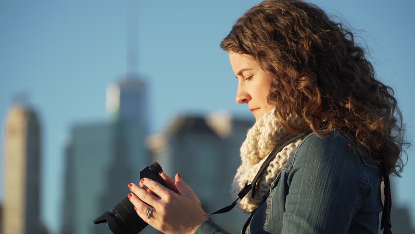 A woman takes pictures of NYC skyline. LD
