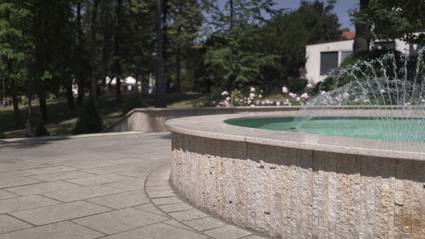 Little fountain with statue of miner, pan and tilt shot.